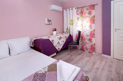 a room with a bed and a table with a curtain at Feniks Apartments in Nesebar