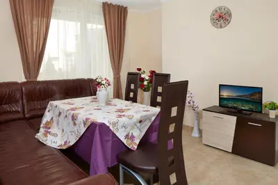 a living room with a table and a couch at Feniks Apartments in Nesebar
