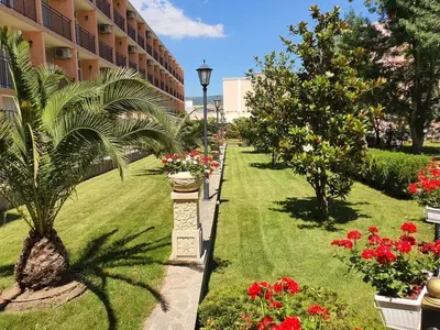 a garden with flowers and plants and a building at Hotel Riva Park - All Inclusive in Sunny Beach