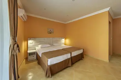 a bedroom with a large bed and yellow walls at Hotel Riva Park - All Inclusive in Sunny Beach
