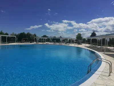 a large blue swimming pool in a resort at Sea View Apartment PRESTIGE FORT BEACH , PREMIER FORT BEACH in Sveti Vlas