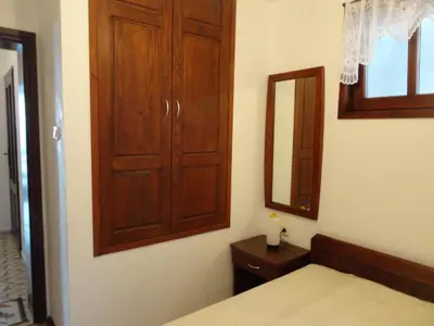 a bedroom with a wooden cabinet and a mirror at Apartments Anita in Nesebar