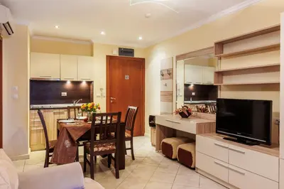 a kitchen and dining room with a table and a television at Apartments DreamBG in Sozopol