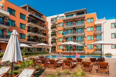 a hotel with chairs and umbrellas and a swimming pool at St. Panteleimon Beach Hotel in Nesebar