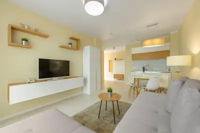 a living room with a couch and a tv and a table at St. Panteleimon Beach Hotel in Nesebar