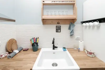 a kitchen with a white sink and a wooden floor at Sea Crib Apartment in Varna City