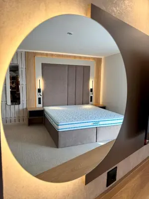 a bedroom with a large bed with a round mirror at Hotel Luxor in Burgas City
