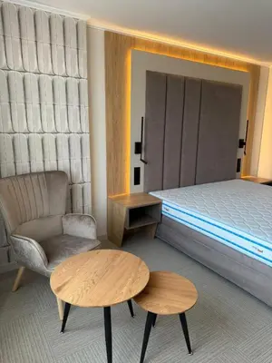 a bedroom with a bed and a chair and a table at Hotel Luxor in Burgas City