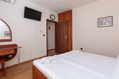 a bedroom with a bed and a desk and a clock at Apartment Sea Shell 1 in Sozopol