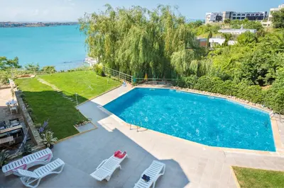 an overhead view of a swimming pool with chairs and the ocean at Apartment Sea Shell 1 in Sozopol