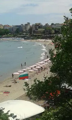 a beach with umbrellas and people in the water at Agalina Sea House in Sozopol