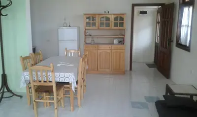 a kitchen with a table and chairs and a refrigerator at Agalina Sea House in Sozopol
