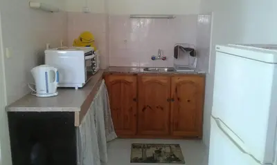 a kitchen with a counter with a sink and a refrigerator at Agalina Sea House in Sozopol