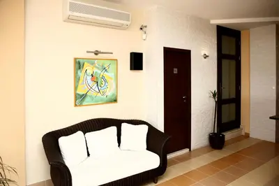 a living room with a couch and a fan at Fjord B&B in Sozopol
