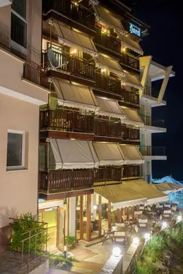 a tall building with a patio with tables and chairs at Fjord B&B in Sozopol