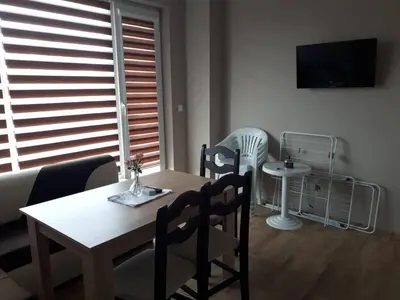 a dining table and chairs in a living room at CAPUCCINO GUEST APARTMENTS - FREE PARKING and Wi-Fi in Sunny Beach