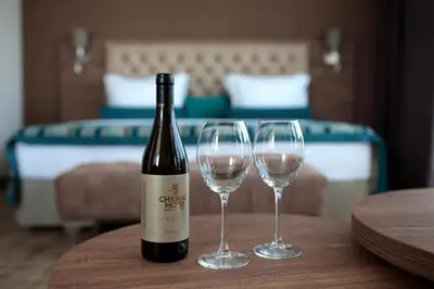 a bottle of wine and two wine glasses on a table at Hotel Cherno More in Varna City