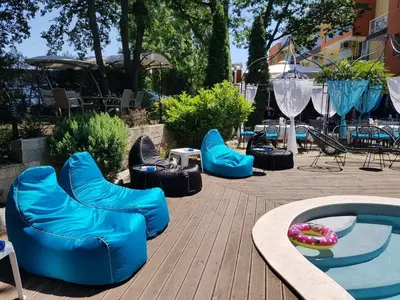 a group of blue chairs next to a swimming pool at Sunrise Hotel in Primorsko