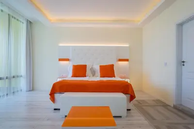 a bedroom with a bed with an orange blanket and orange pillows at Hotel Perla Beach Luxury - All Inclusive & Free Beach Access in Primorsko