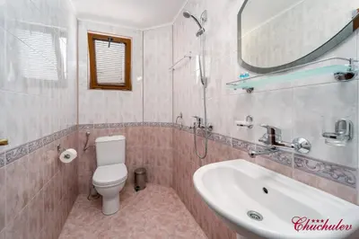 a bathroom with a toilet and a sink and a mirror at Hotel Chuchulev in Sozopol