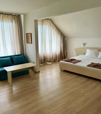a bedroom with a bed and a blue couch at Family Hotel Magnolia, Sunny Beach in Sunny Beach