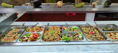 a buffet line with many trays of food at Hotel Caesars Palace in Sunny Beach