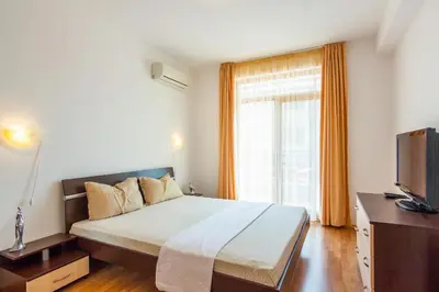 a bedroom with a bed and a tv and a window at Edmond Apartment-Highspeed-Internet-Free! in Aheloy