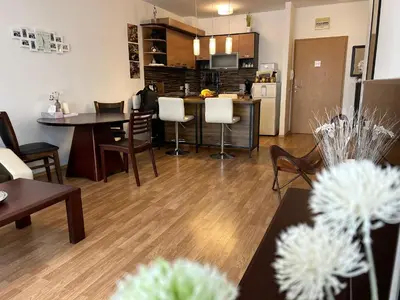 a living room with tables and chairs and a kitchen at Edmond Apartment-Highspeed-Internet-Free! in Aheloy