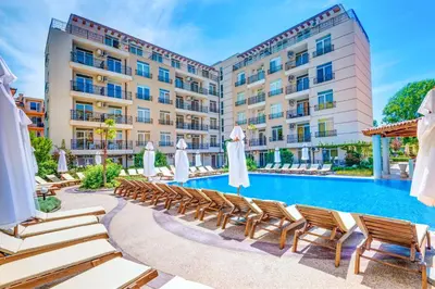 a hotel pool with lounge chairs and umbrellas at Dawn Park Complex in Sunny Beach