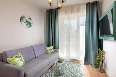 a living room with a couch and a tv at Dawn Park Complex in Sunny Beach