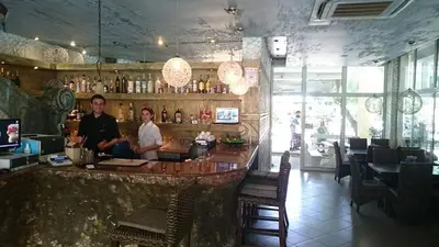 two people standing at a bar in a restaurant at Yassen Holiday Village in Sunny Beach