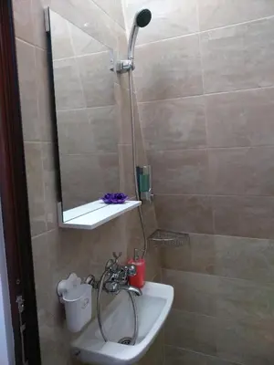 a bathroom with a sink and a shower with a mirror at penyrent in Varna City
