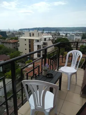 two white chairs and a table on a balcony at penyrent in Varna City