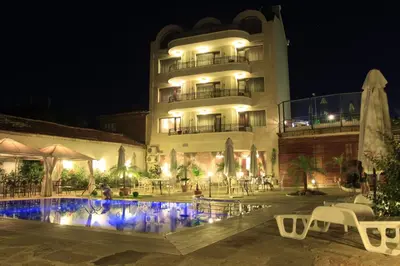 a building with a swimming pool in front of a building at night at Guest House Palazzo in Byala