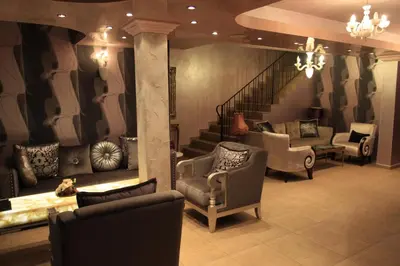 a living room with chairs and a stair case at Guest House Palazzo in Byala