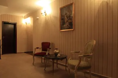 a room with chairs and a table and a painting at Guest House Palazzo in Byala