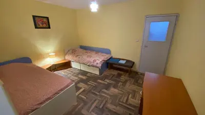 a small room with two beds and a table at Аria B&B in Burgas City