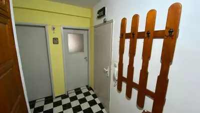 a bathroom with a door and a checkered floor at Аria B&B in Burgas City
