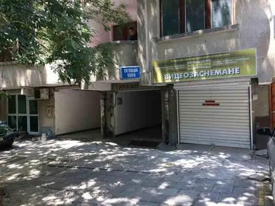 a building with a garage with a sign on it at Аria B&B in Burgas City