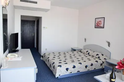 a hotel room with a bed and a desk at Sineva Park Hotel - All Inclusive in Sveti Vlas