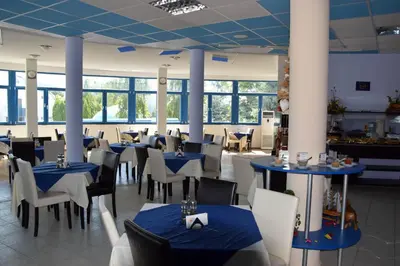 a dining room with blue tables and white chairs at Sineva Park Hotel - All Inclusive in Sveti Vlas