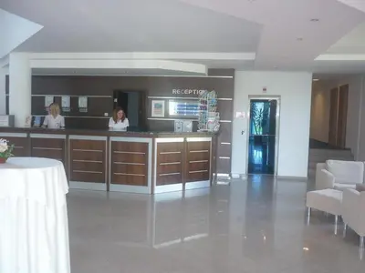 two women standing at a counter in a lobby at Sineva Beach Hotel - All Inclusive in Sveti Vlas