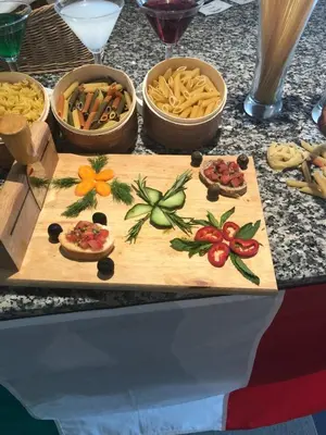 a wooden cutting board with food on a table at Sineva Beach Hotel - All Inclusive in Sveti Vlas
