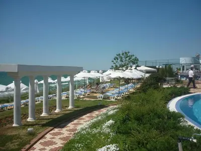 a resort with a pool and chairs and umbrellas at Sineva Beach Hotel - All Inclusive in Sveti Vlas