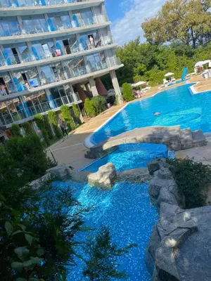 a swimming pool in front of a large building at Hotel Kamenec in Kiten
