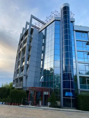 a tall glass building with a lot of windows at Hotel Kamenec in Kiten