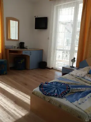 a bedroom with a bed and a television on the wall at Primorsko Apartments in Primorsko
