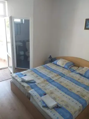 a bedroom with a bed with blue sheets and pillows at Primorsko Apartments in Primorsko