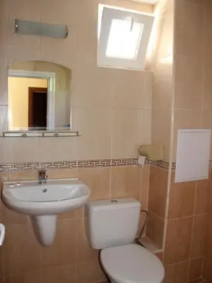 a bathroom with a toilet and a sink and a mirror at Hotel Sapphire in Primorsko