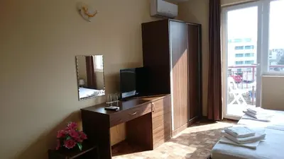 a hotel room with a television and a dresser with a mirror at Hotel Sapphire in Primorsko